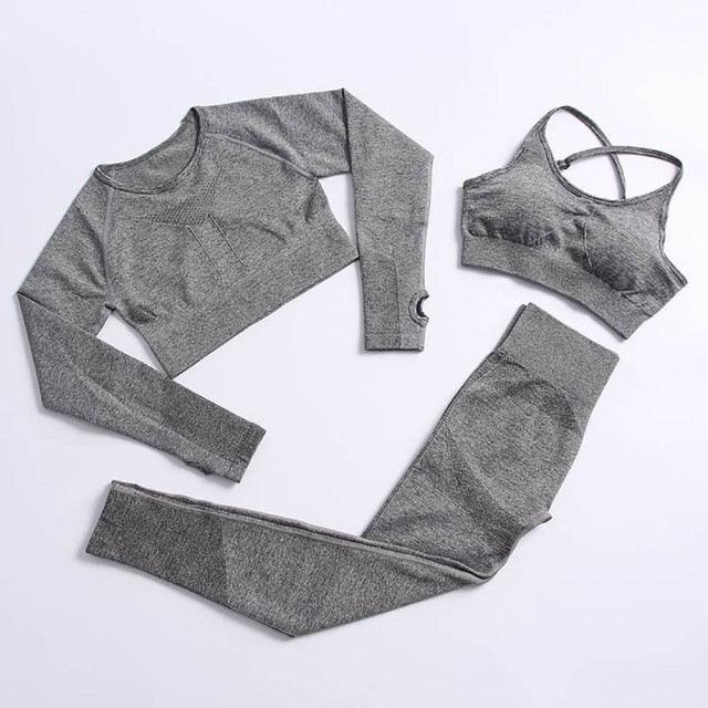 Gray athletic outfit with long-sleeve top, sports bra, and leggings on a white background