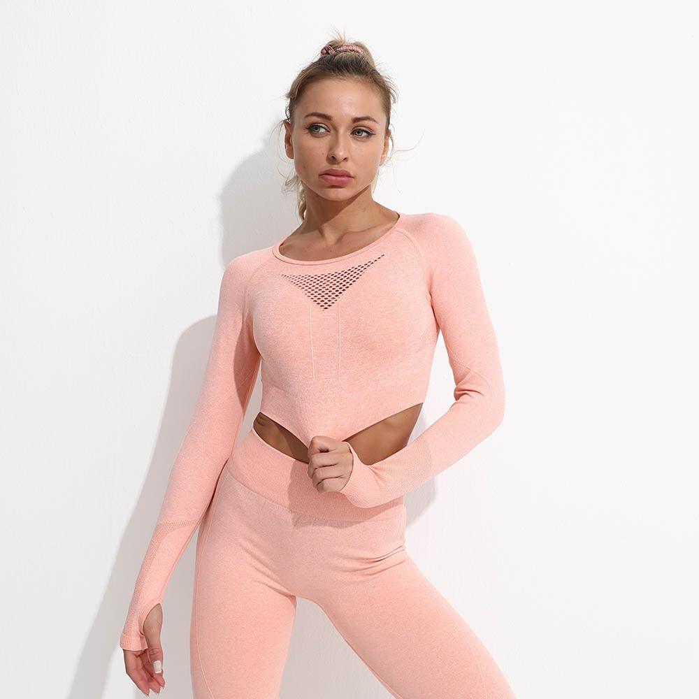Woman wearing a pink long-sleeve top and pants with mesh detail on a white background