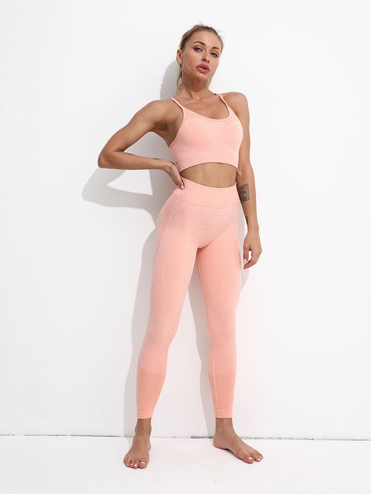 Woman wearing a pink athletic outfit against a white background