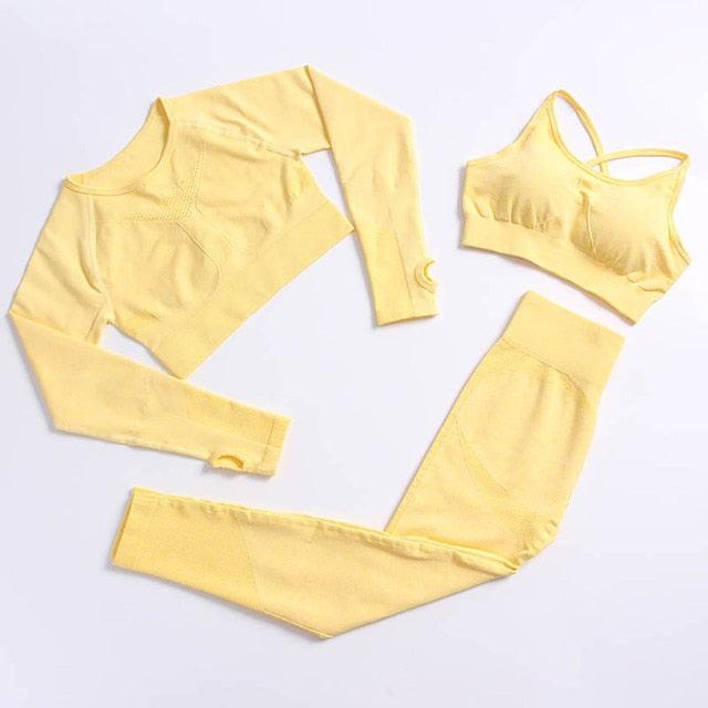 Yellow long-sleeve crop top, leggings, and sports bra set on a light gray background
