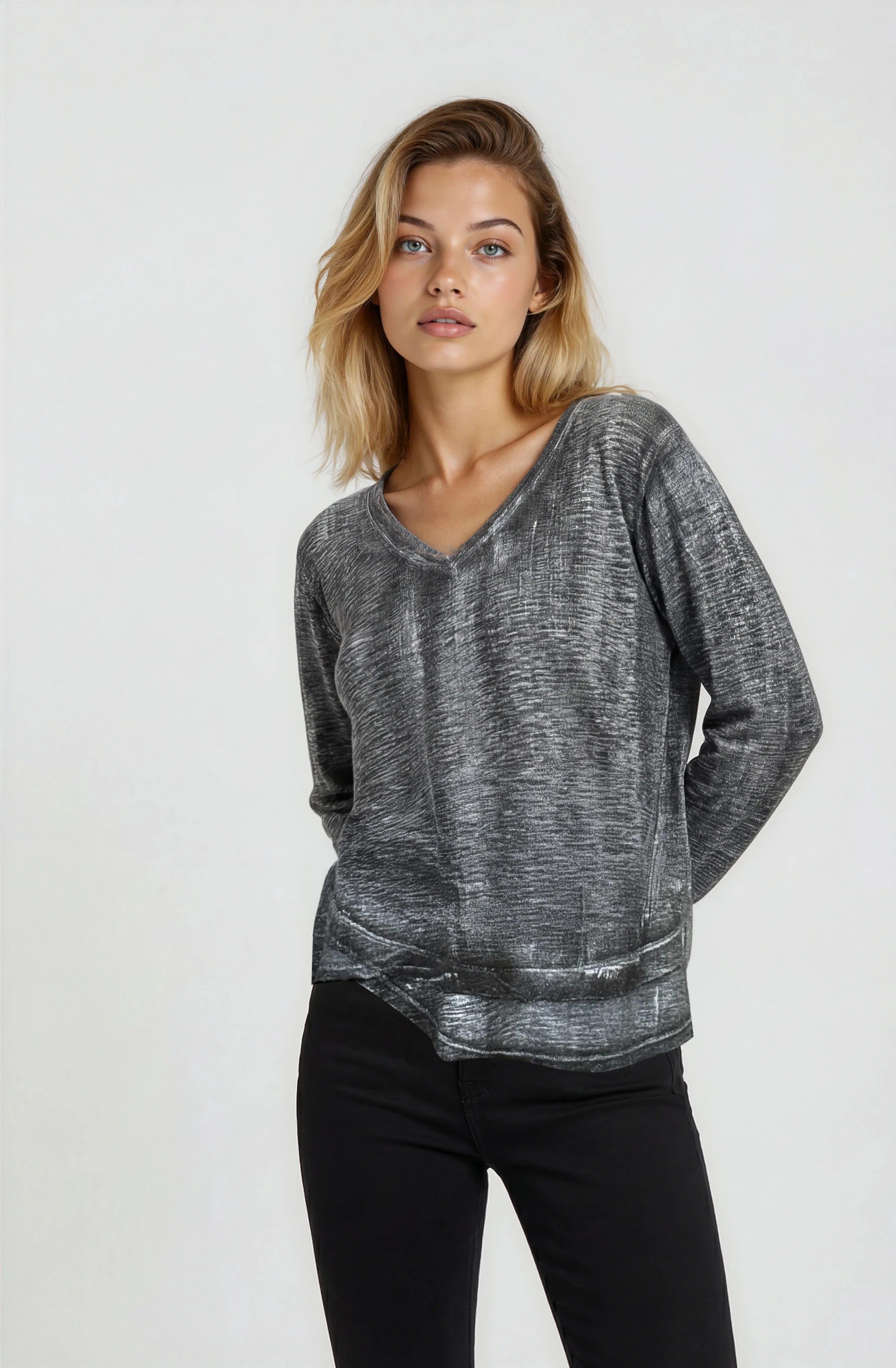 Woman wearing a gray sweater and black pants on a white background