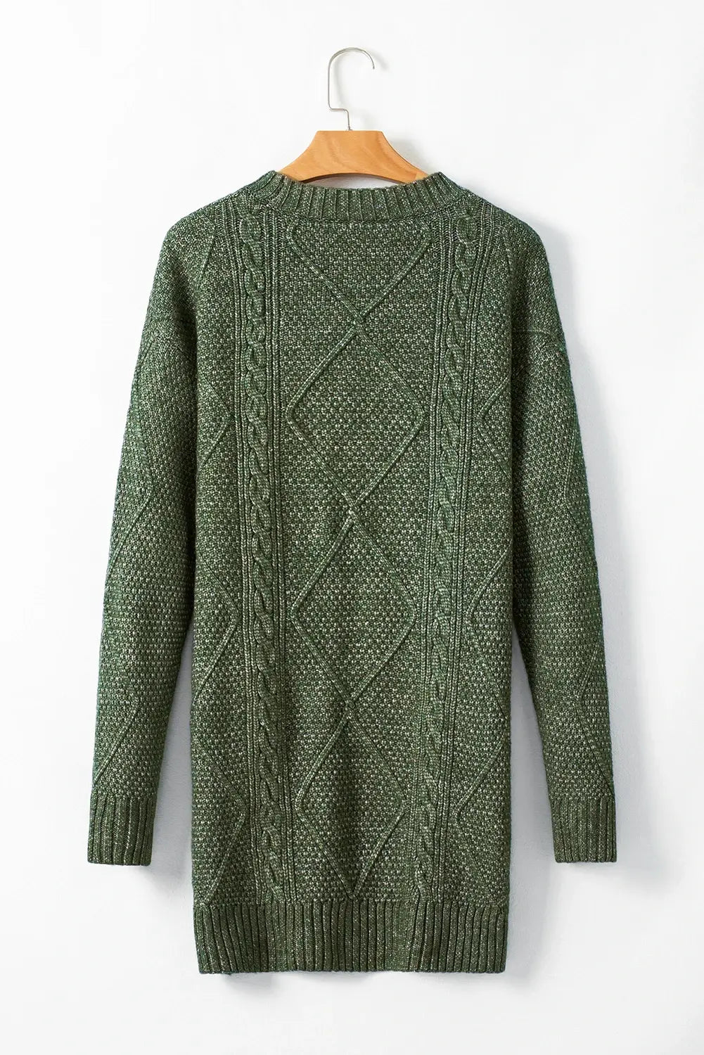 Green cable knit sweater on a hanger against a white background