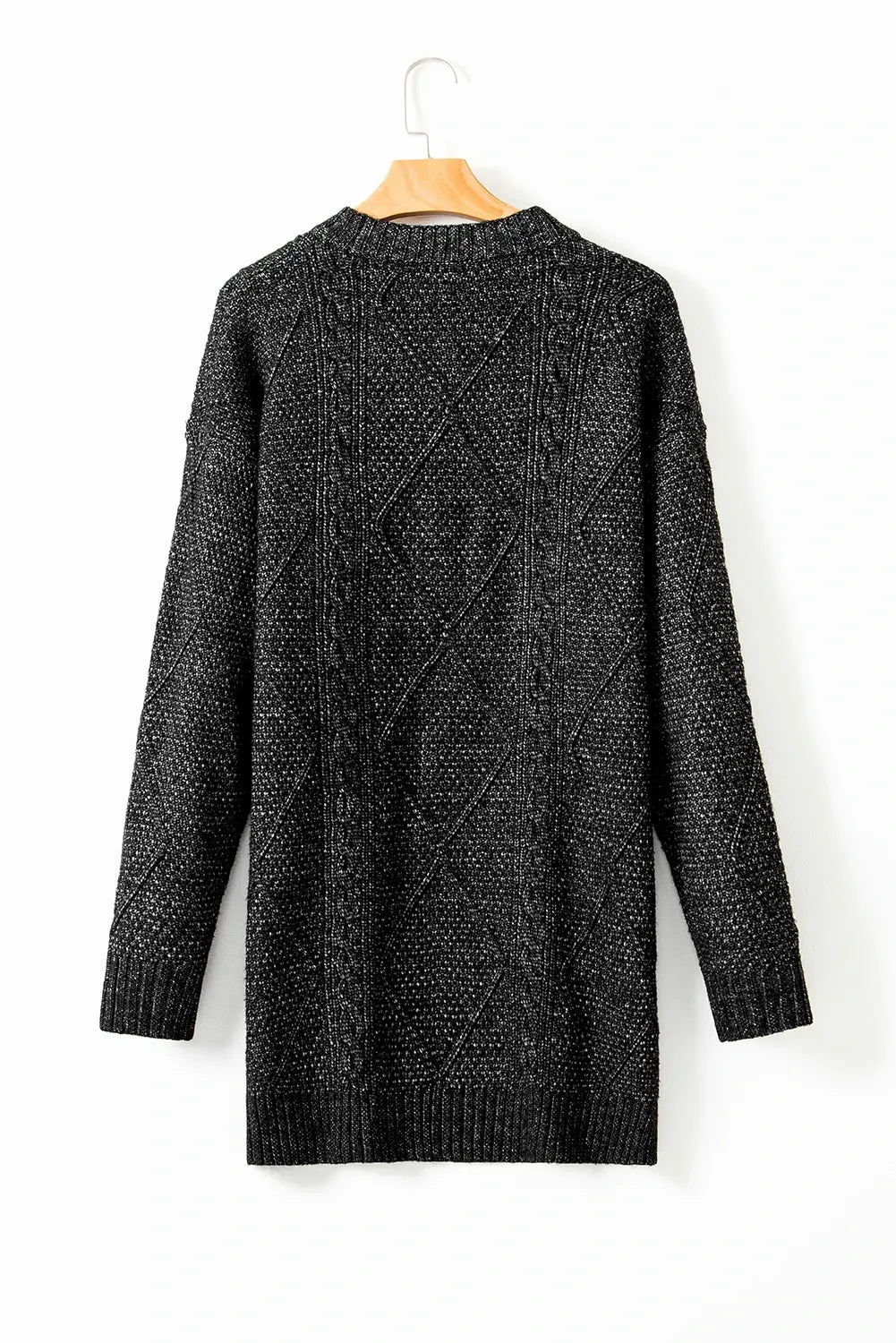Black knitted cardigan on a wooden hanger against a white background