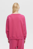 Person wearing a pink sweatshirt and pants on a white background