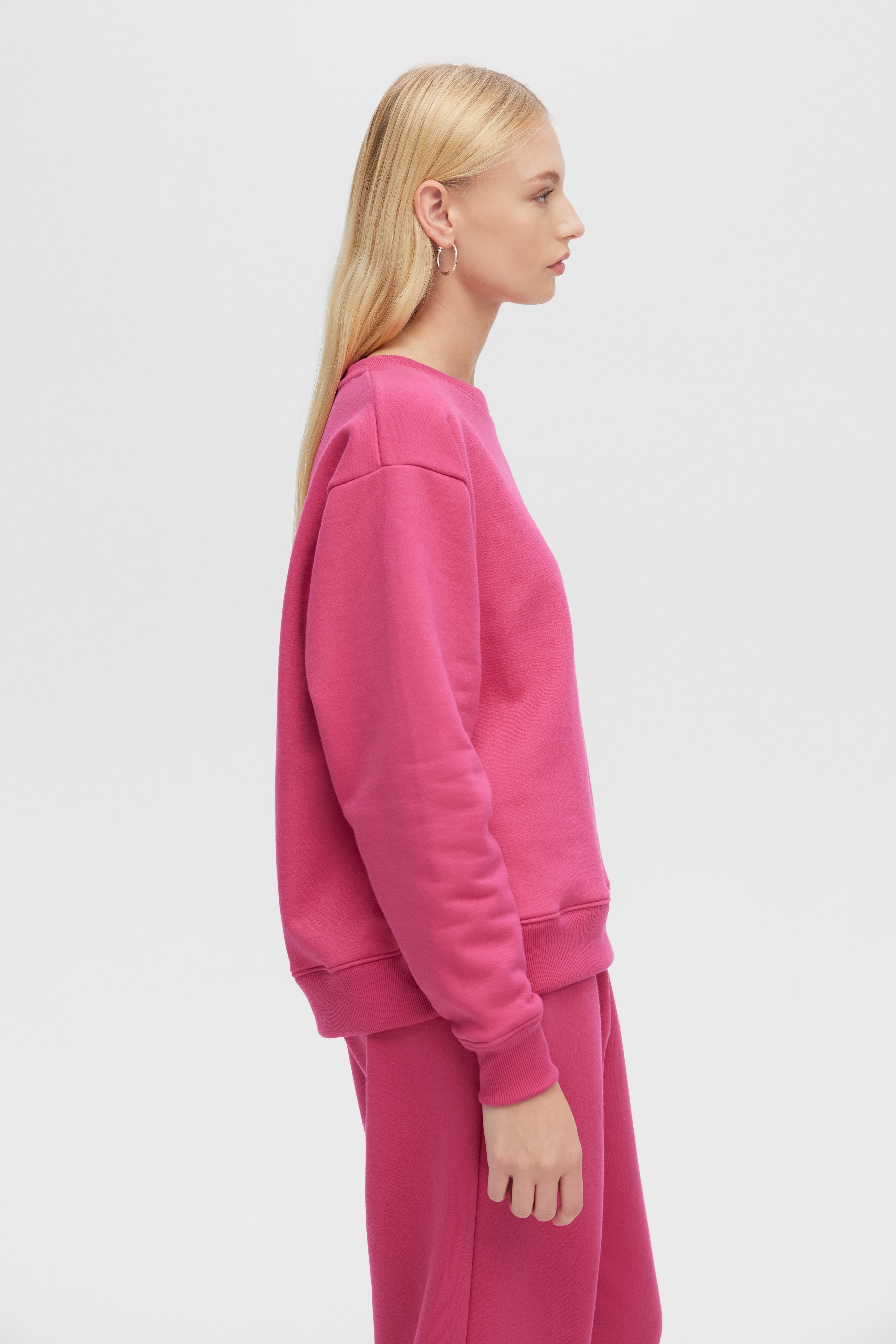 Person wearing a pink outfit on a light gray background
