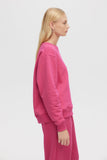 Person wearing a pink outfit on a light gray background