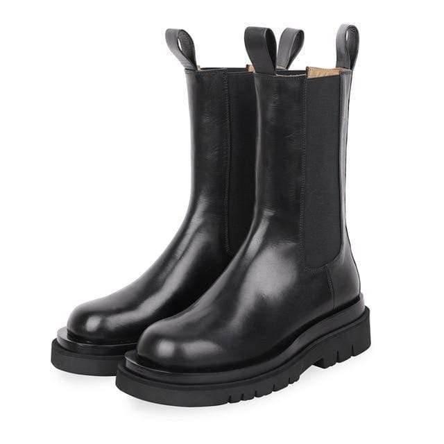 Pair of black leather boots with elastic sides on a white background