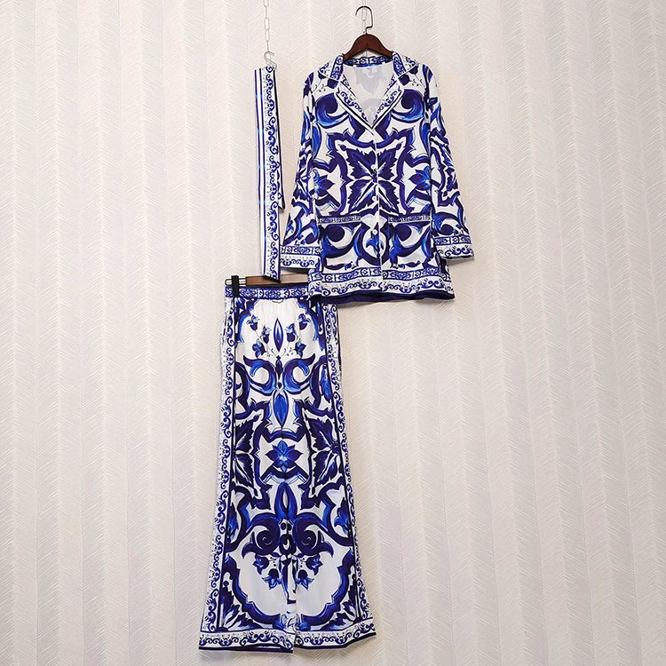 Blue and white patterned outfit on a hanger against a white curtain background
