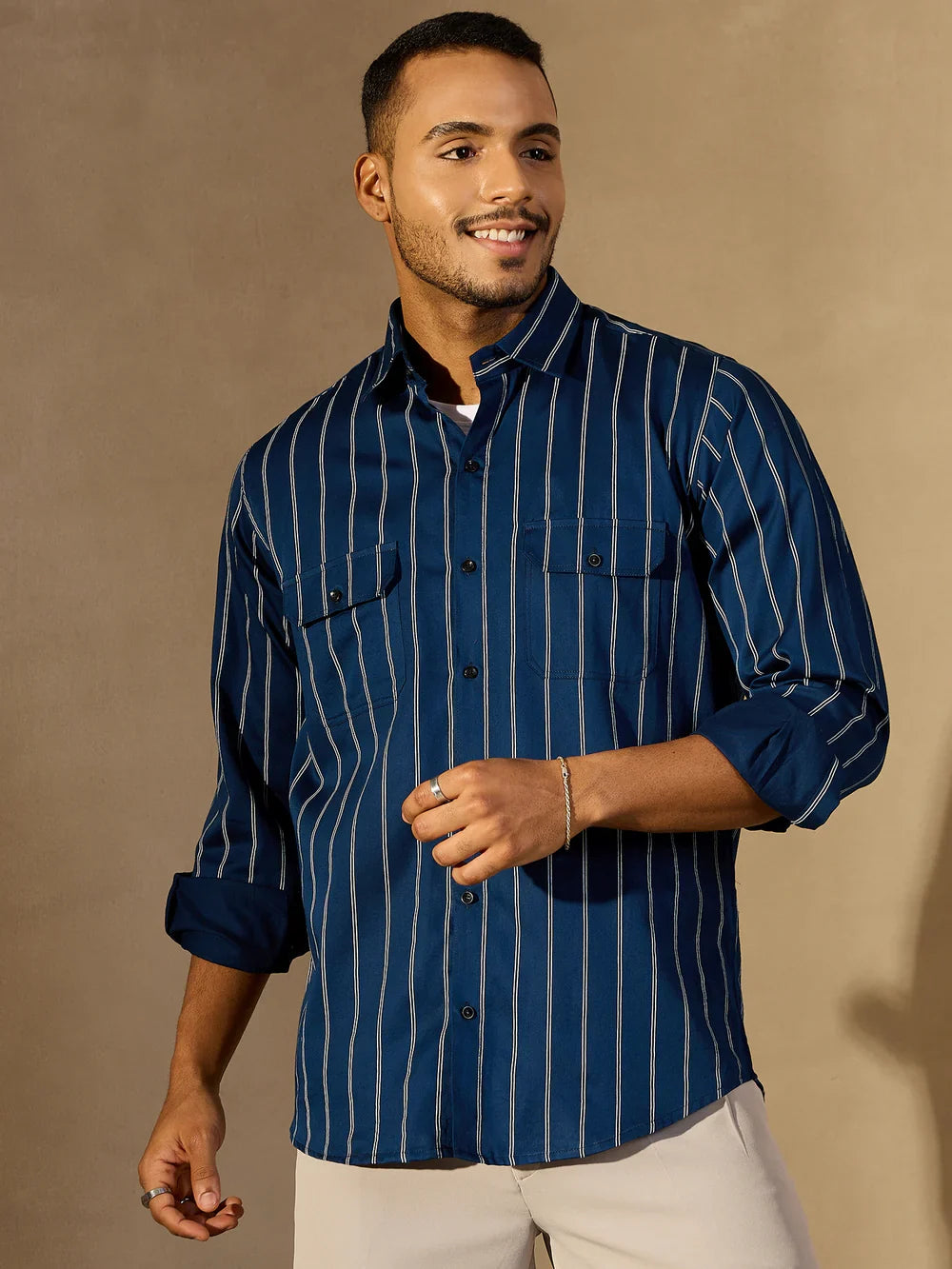 Man wearing a blue striped shirt against a beige background
