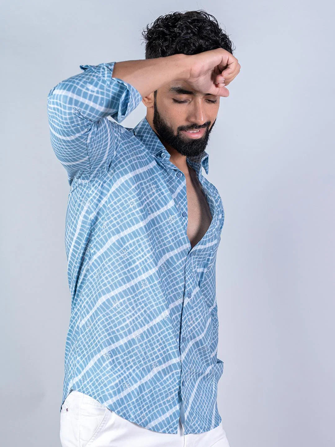 Man wearing a blue checkered shirt against a gray background