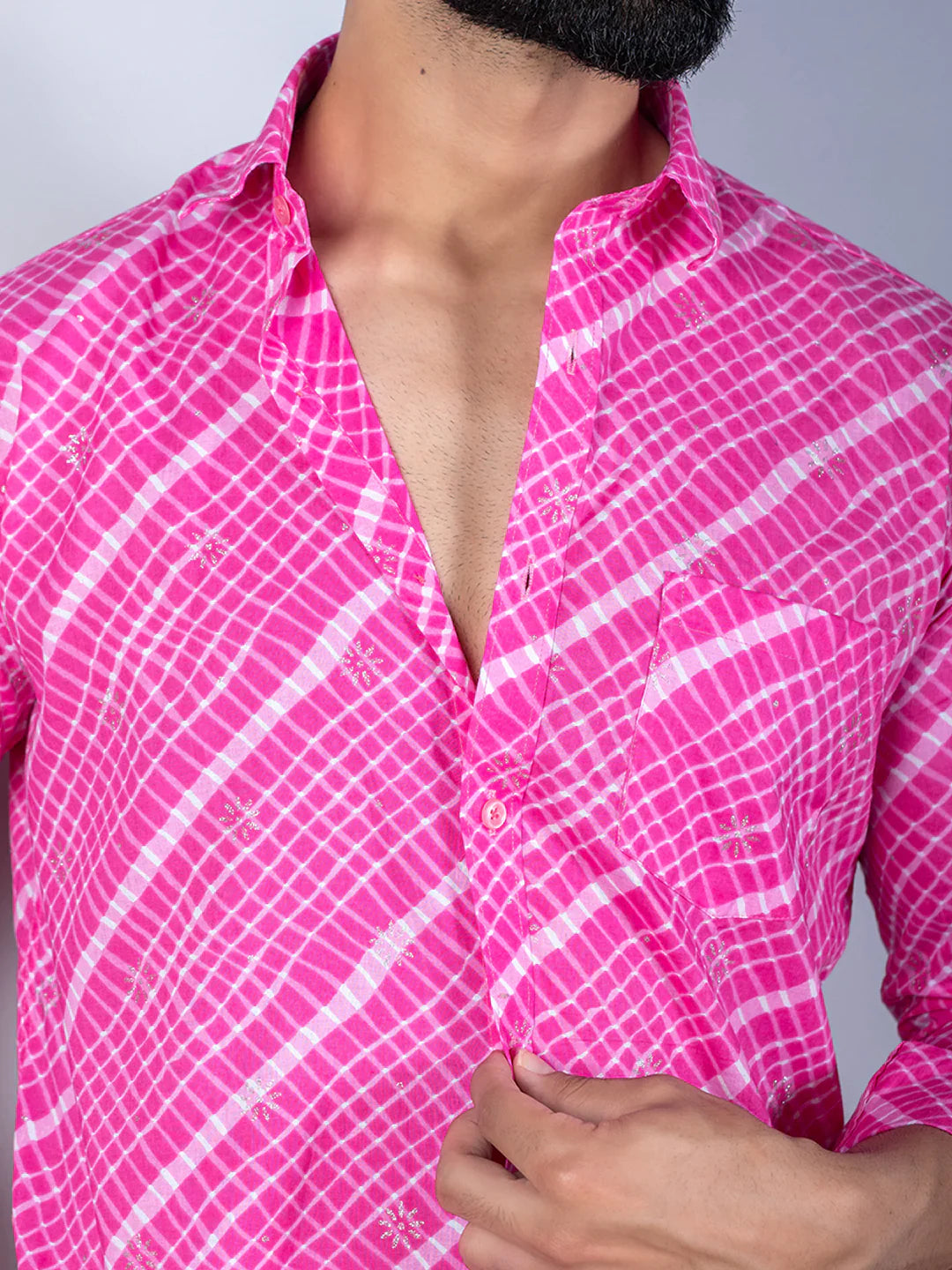 Close-up of a person wearing a pink and white checkered shirt against a gray background