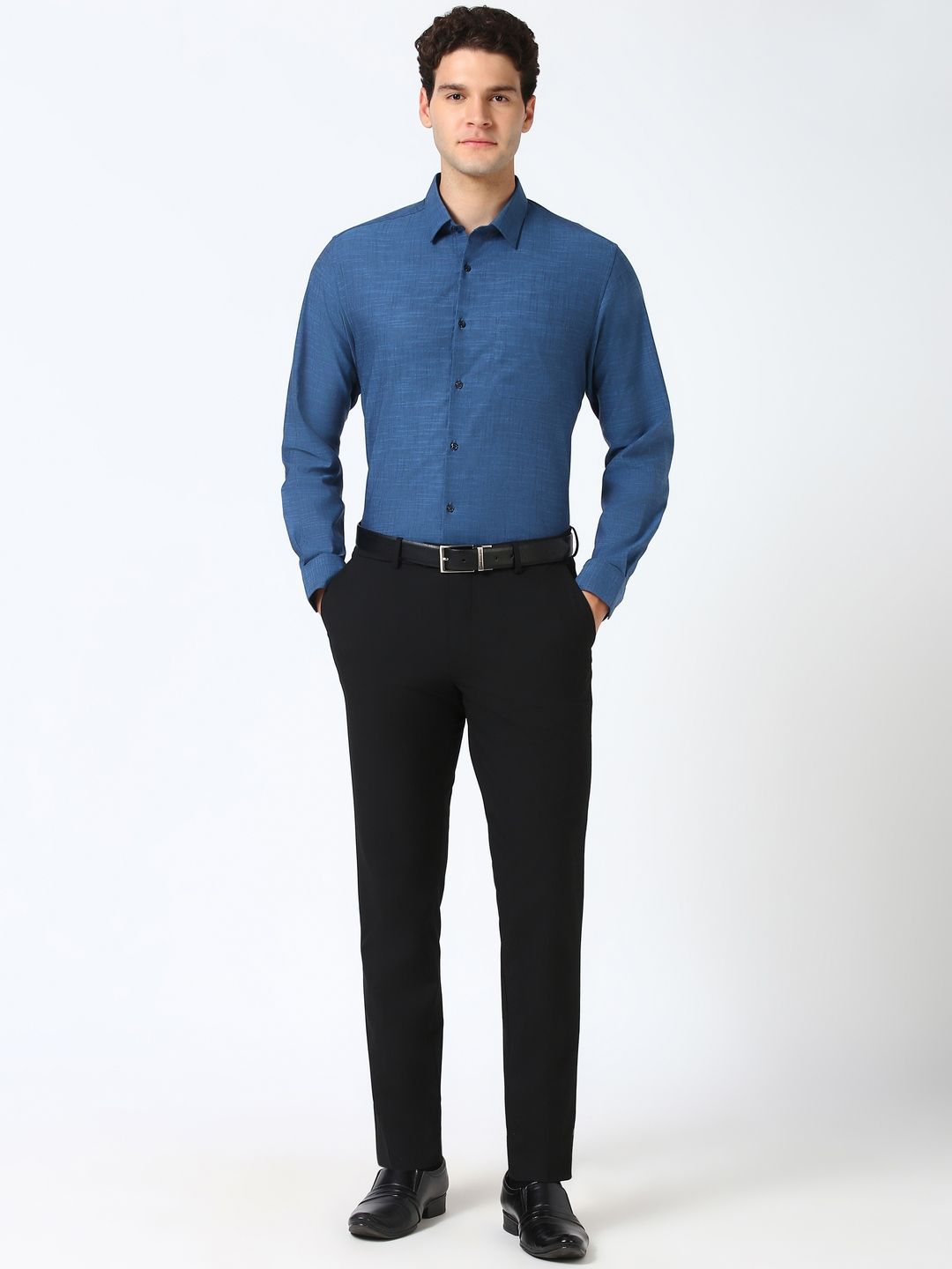 Man wearing a blue shirt and black pants on a white background