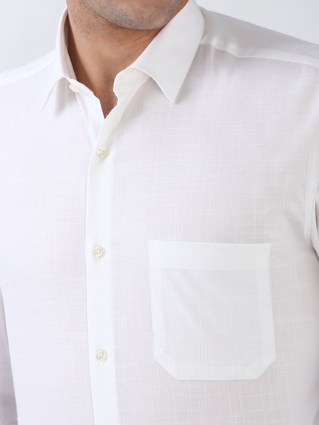 Close-up of a white dress shirt with collar and buttons on a plain background