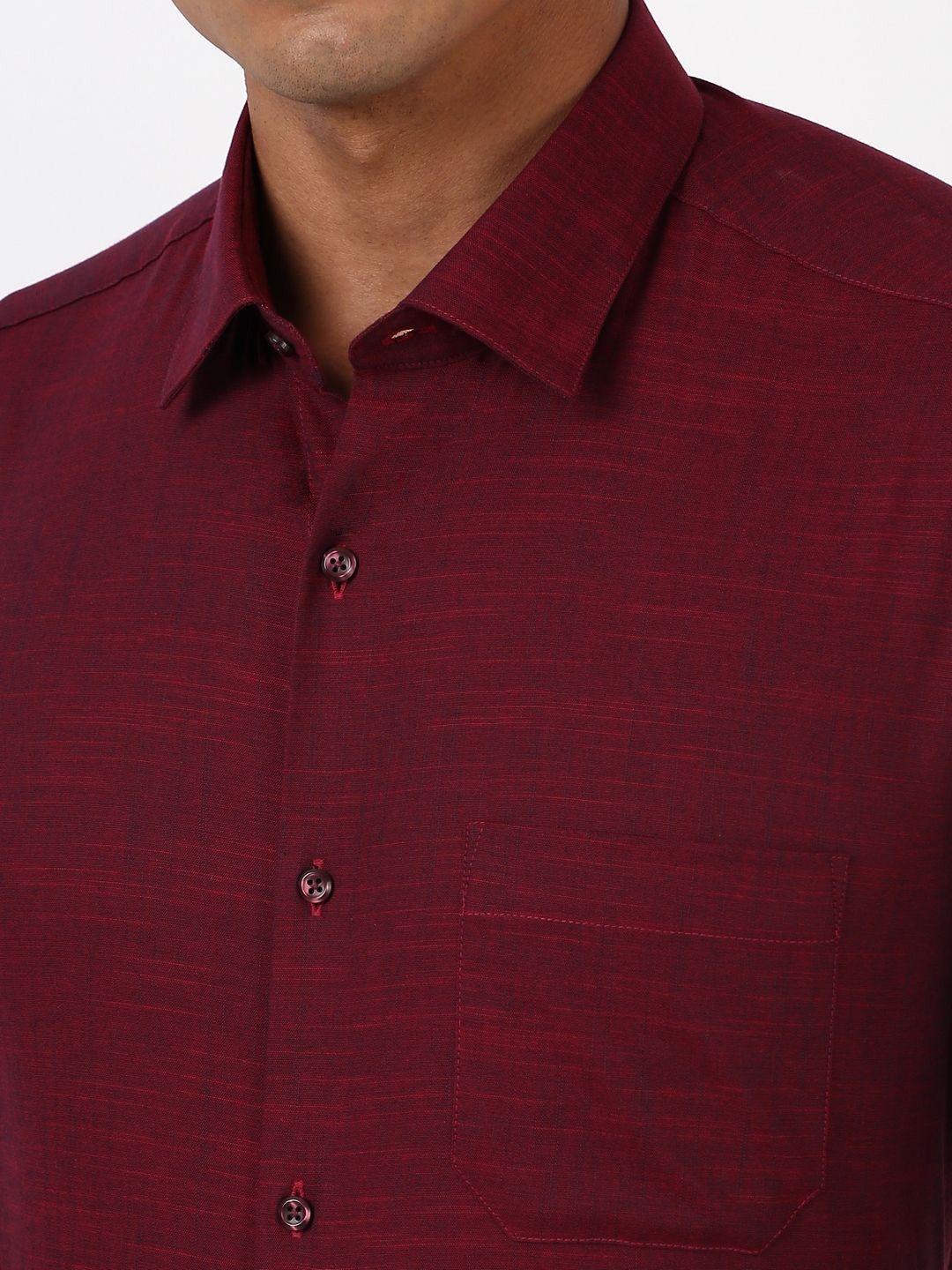 Close-up of a maroon shirt with a collar and buttons on a white background