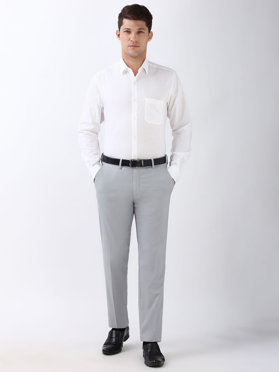 Man wearing a white dress shirt, gray pants, and black shoes on a white background