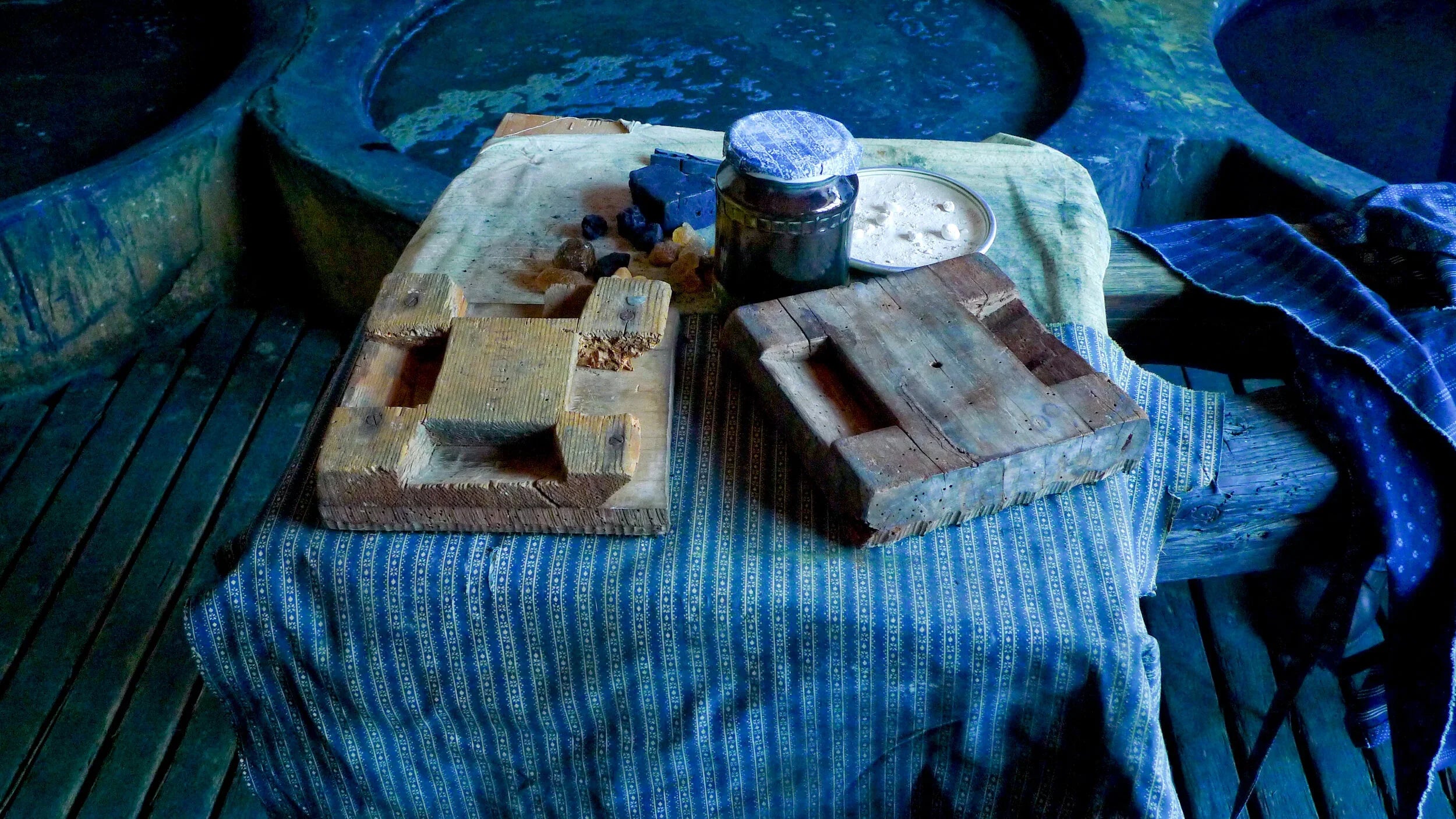 Wooden blocks and a jar on a blue striped cloth with a blue background