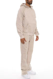 Man wearing a beige tracksuit on a white background