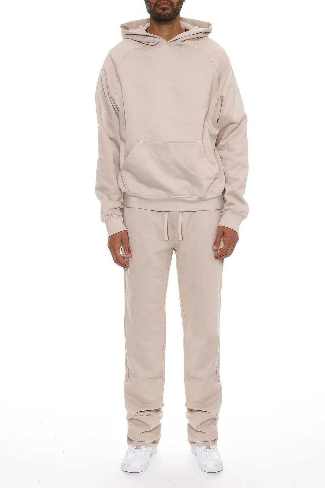 Person wearing a beige tracksuit on a white background
