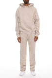 Person wearing a beige tracksuit on a white background