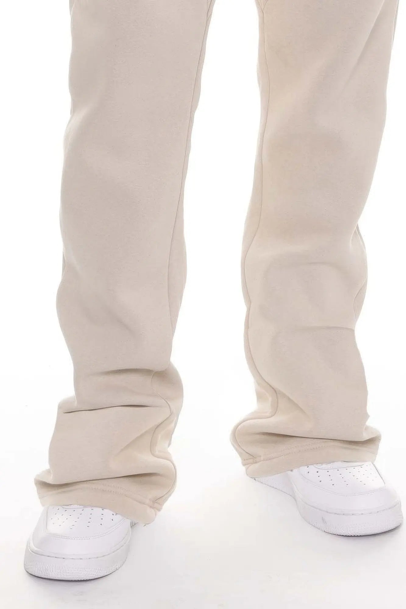 Beige pants worn by a person on a white background