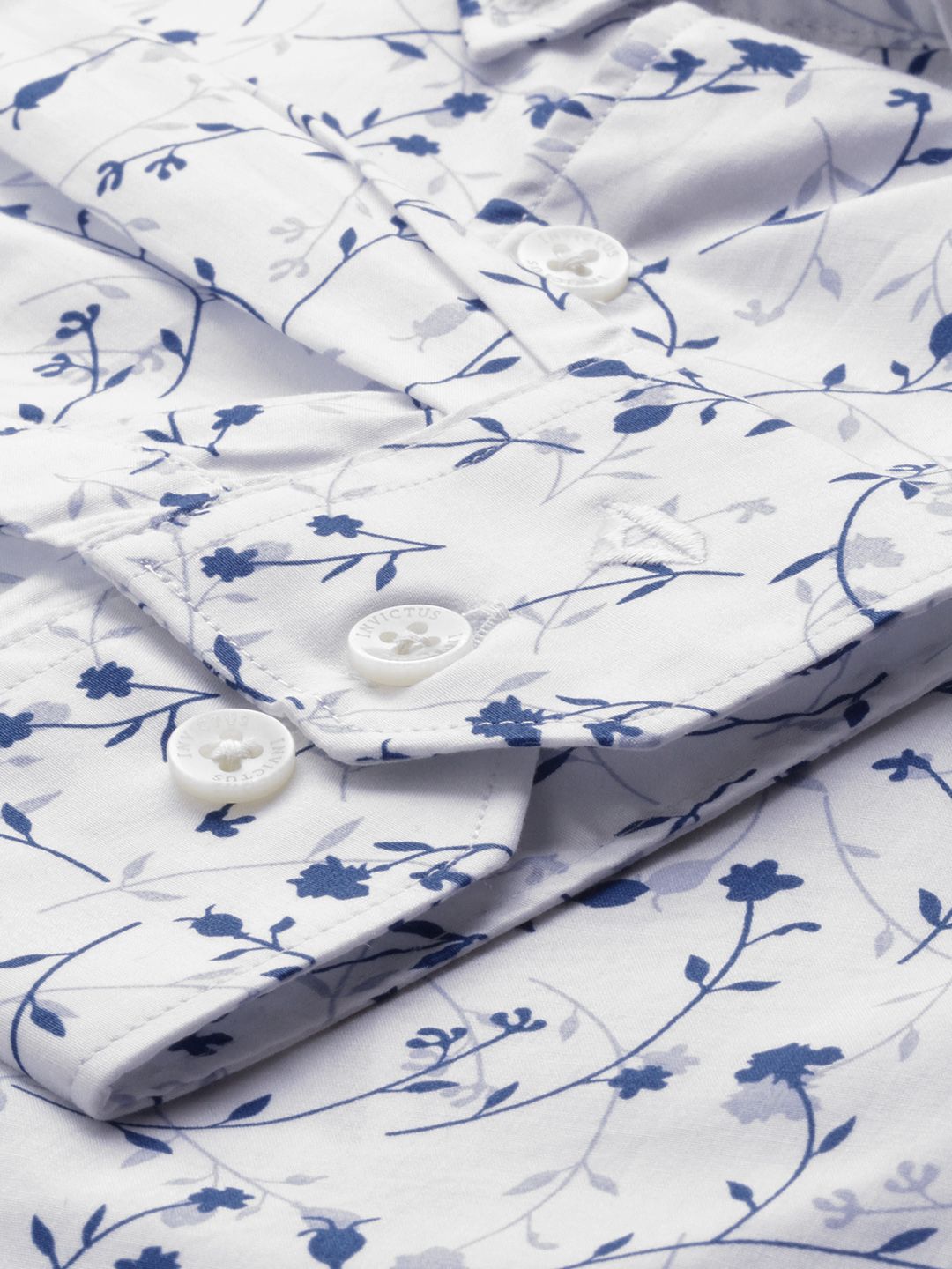 White shirt with blue floral pattern and buttons on a white background