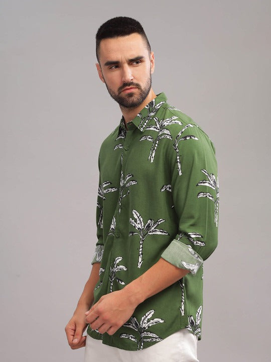 Man wearing a green patterned shirt against a gray background
