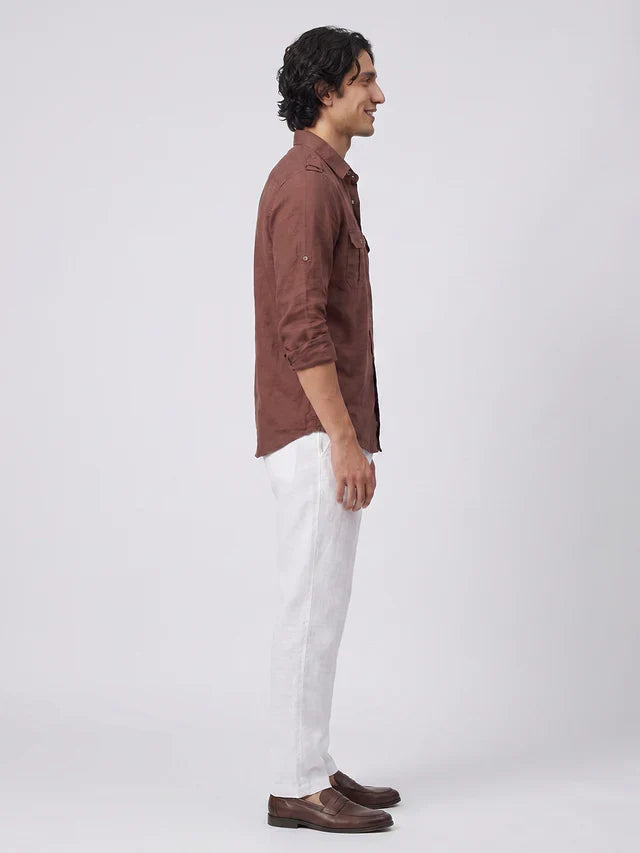 Man wearing a brown shirt and white pants on a white background