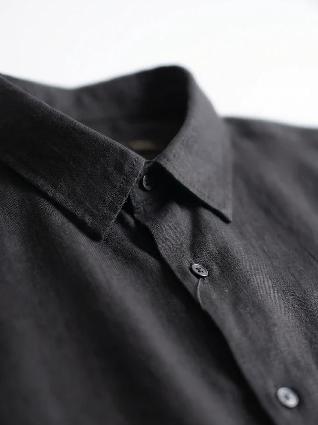 Close-up of a black button-up shirt with a blurred background