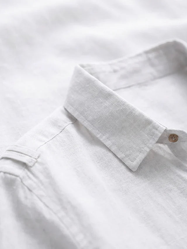 Close-up of a white shirt collar with a button on a white background