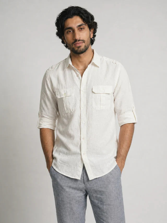 Man wearing a light-colored shirt and gray pants against a plain background