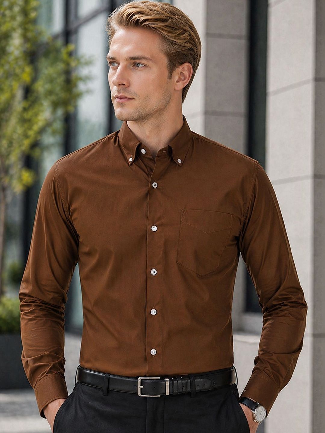 Man wearing a brown dress shirt standing outdoors.
