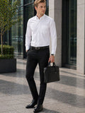 Man in formal attire holding a briefcase outside a building