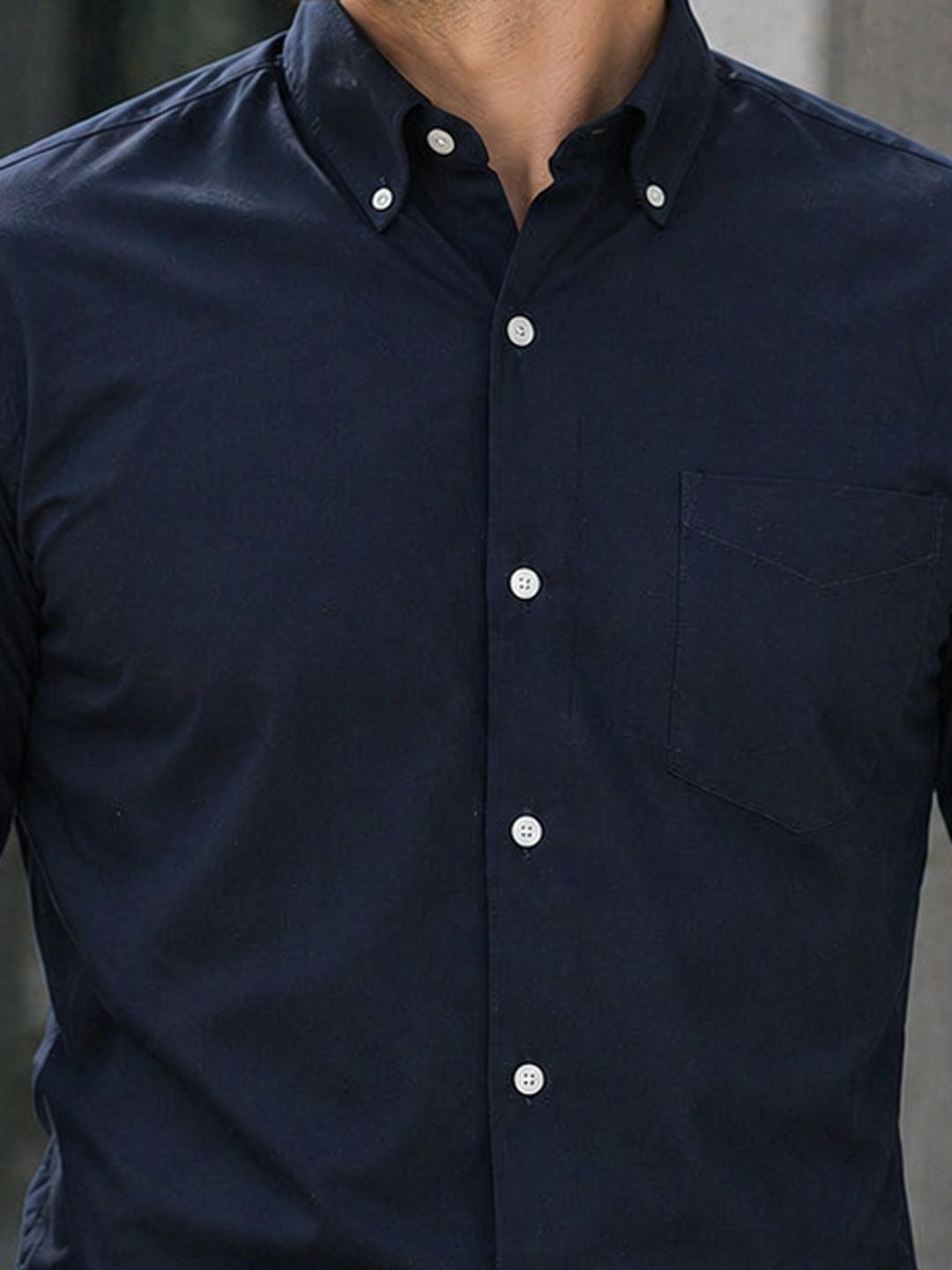 Navy blue button-up shirt worn by a person with a blurred background