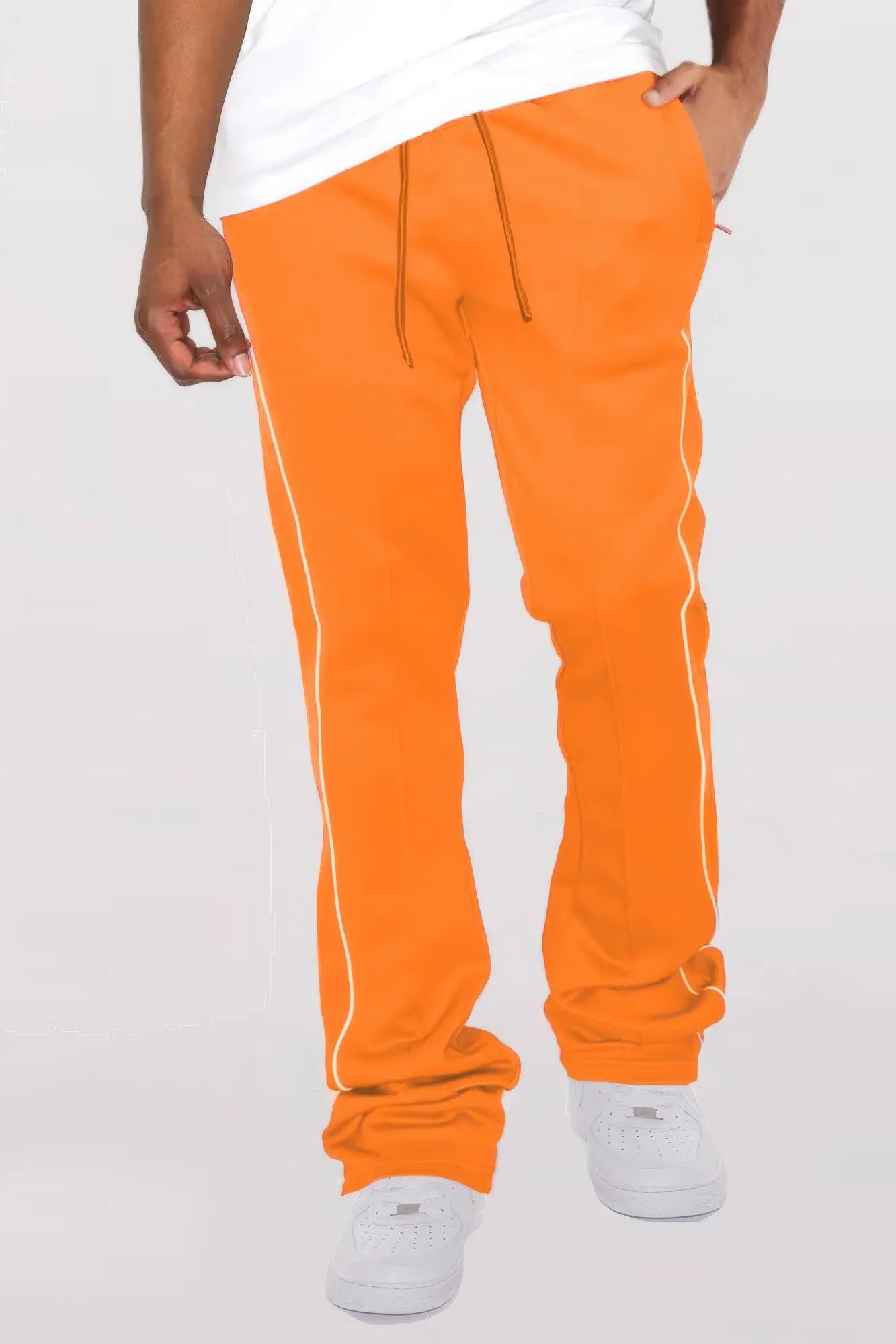 Orange sweatpants with white stripes worn by a person on a white background