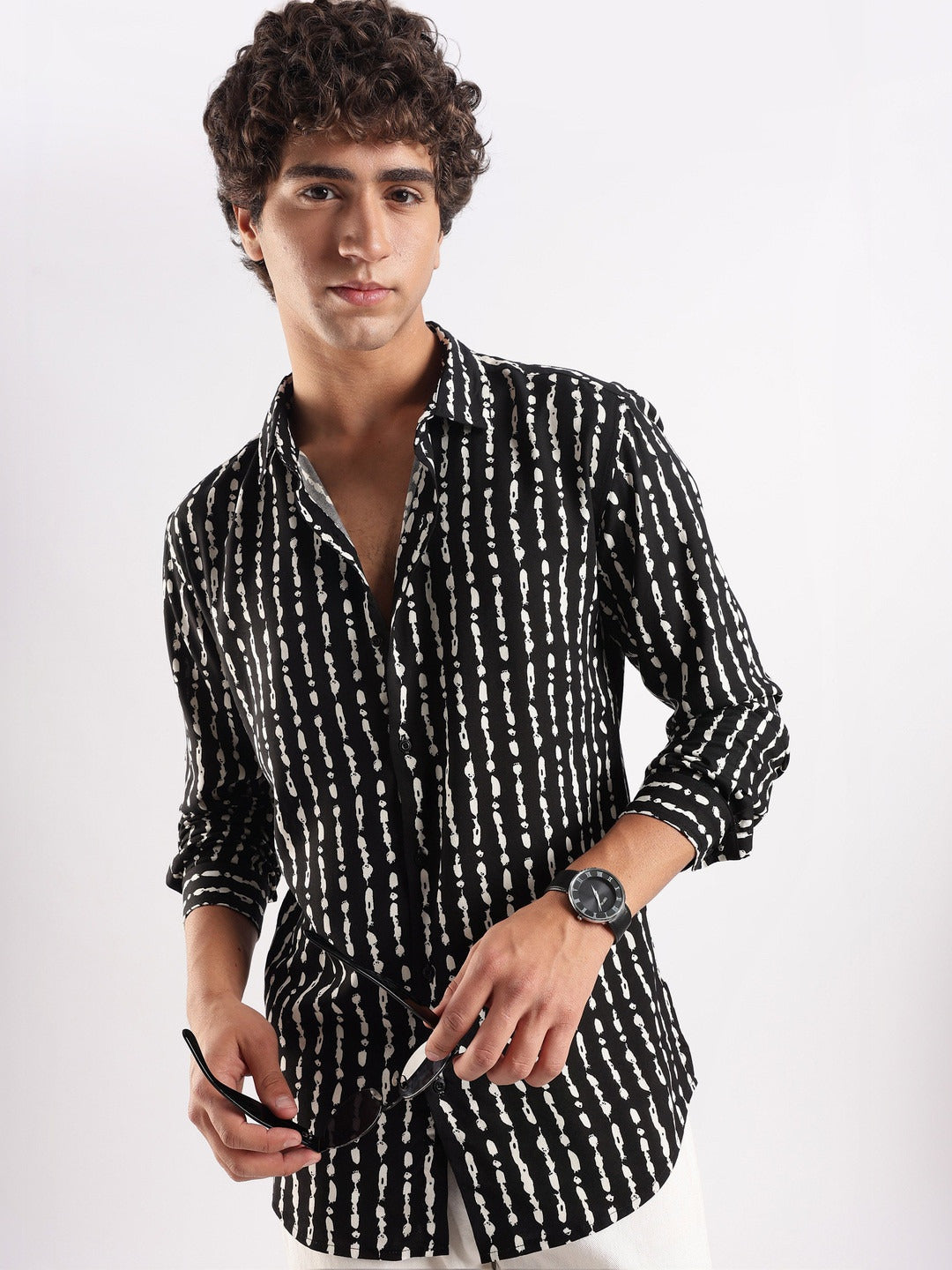Man wearing a black and white patterned shirt on a white background