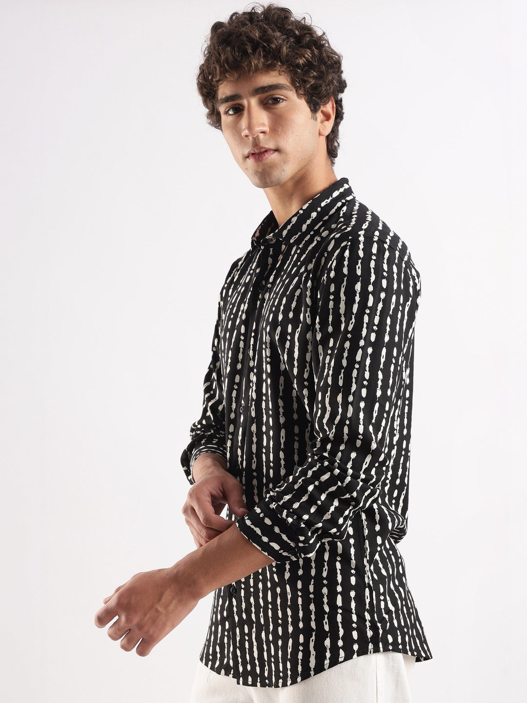 Man wearing a black and white patterned shirt on a white background