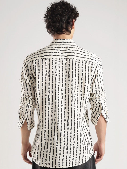 Person wearing a black and white patterned shirt on a plain background