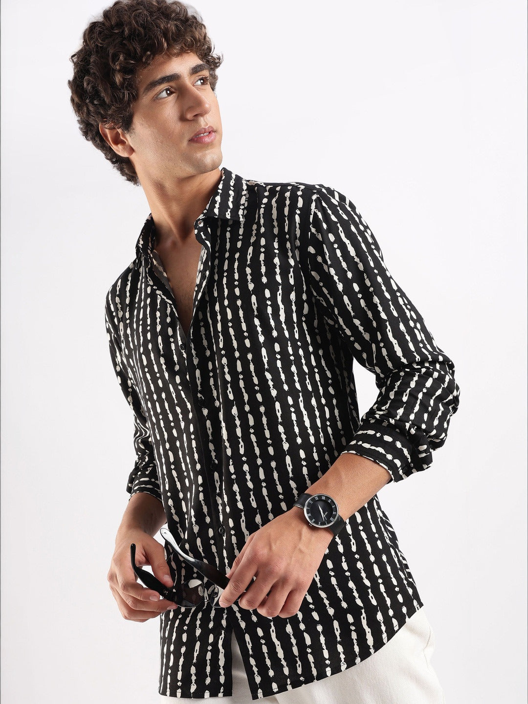 Man wearing a black and white patterned shirt on a white background