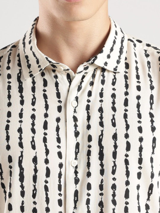 Close-up of a person wearing a black and white patterned shirt.