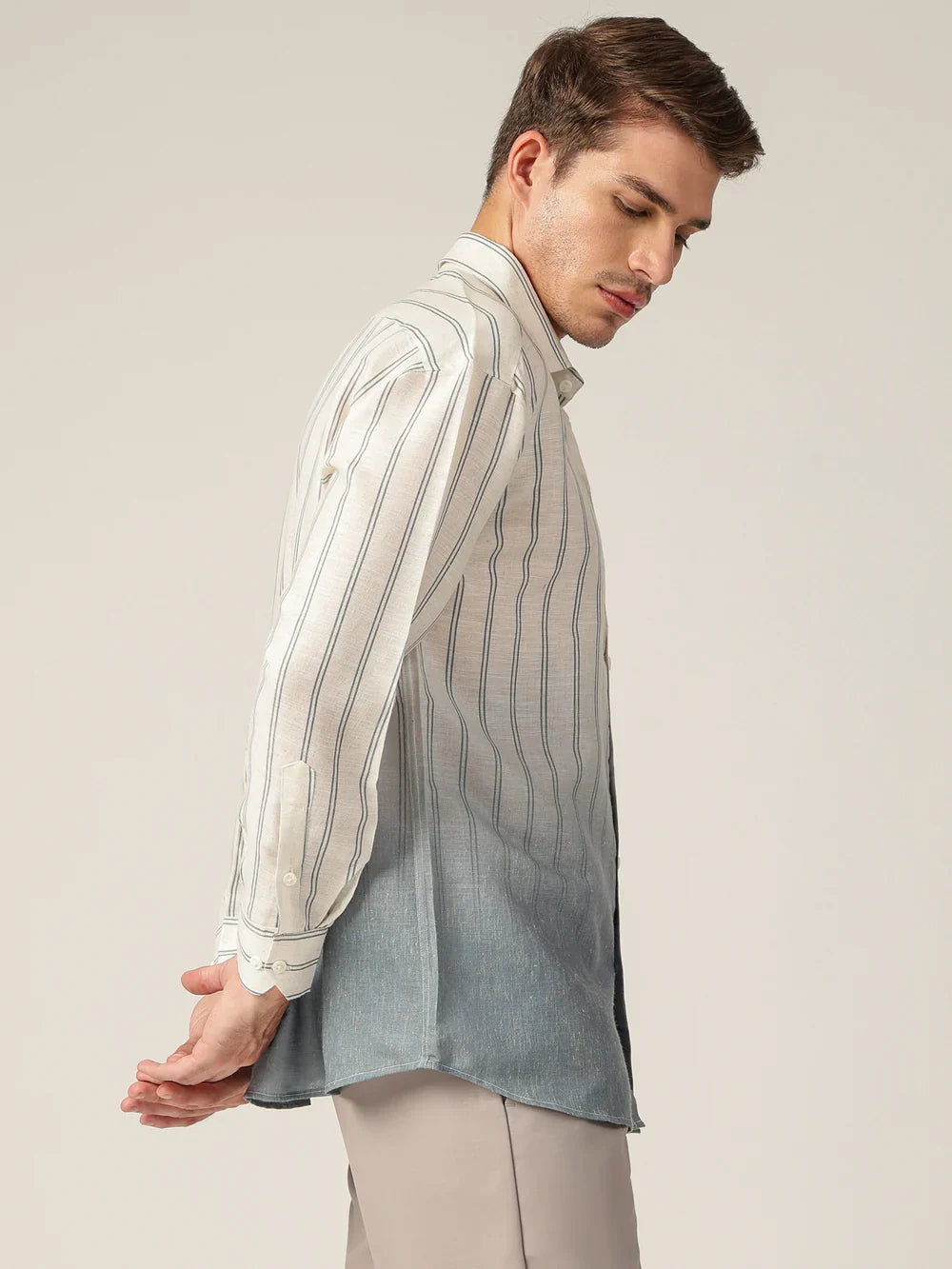 Man wearing a striped shirt with a plain background