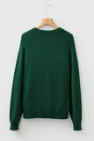 Green sweater on a wooden hanger against a white background