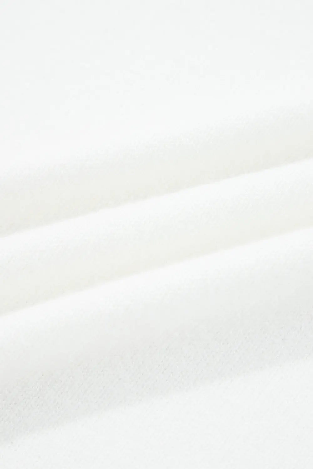 A close-up of draped white fabric with soft folds and a subtle textured surface.