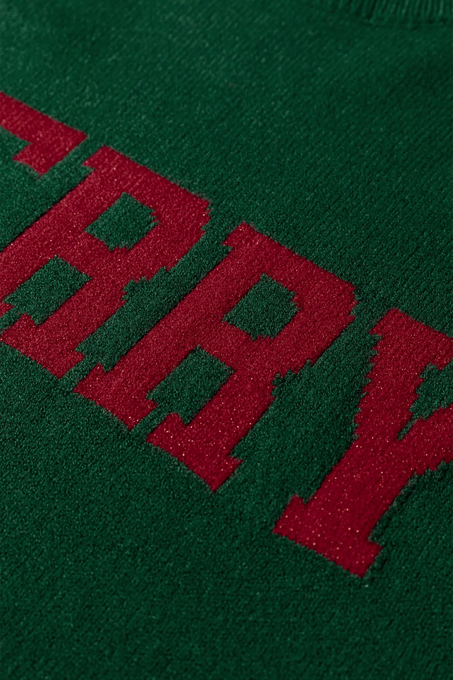Green fabric with red embroidered text on a green background