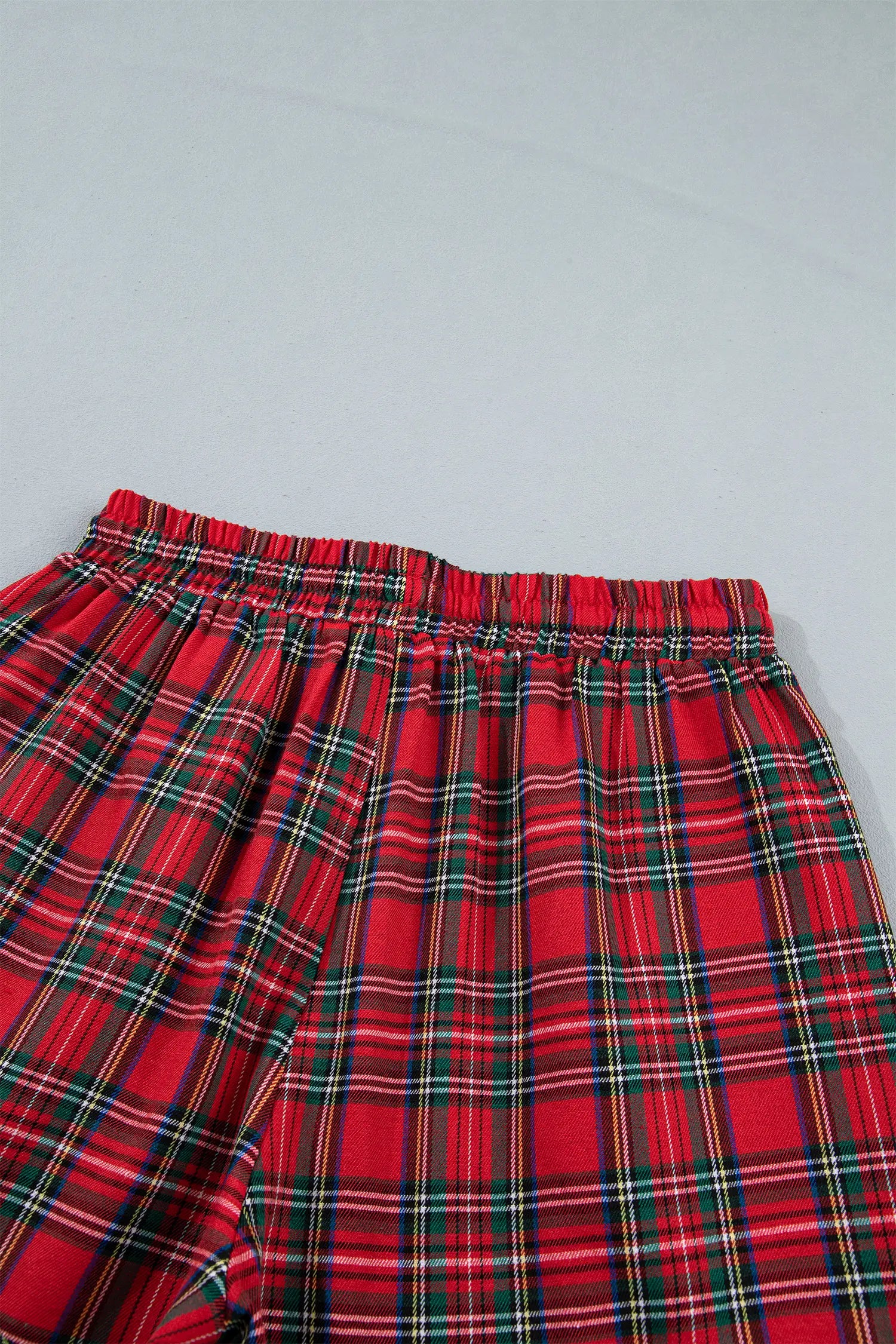 Red plaid pajama pants with green, white, yellow tartan and elastic waistband.