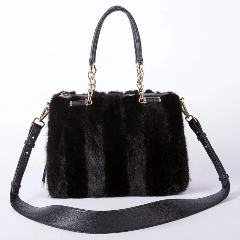 Black fur handbag with gold accents on a white background