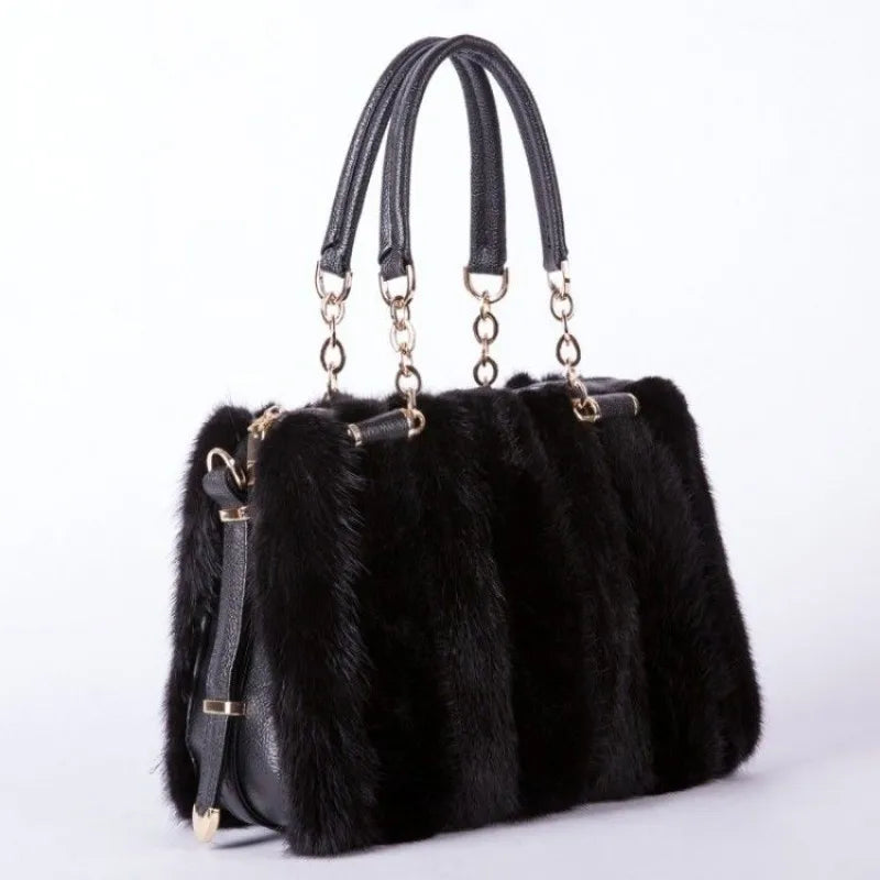 Black fur handbag with gold accents on a white background
