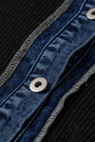 Close-up detail of a dark blue denim button panel with silver metal snap buttons and contrast gray stitching, bordered by a black ribbed knit fabric.