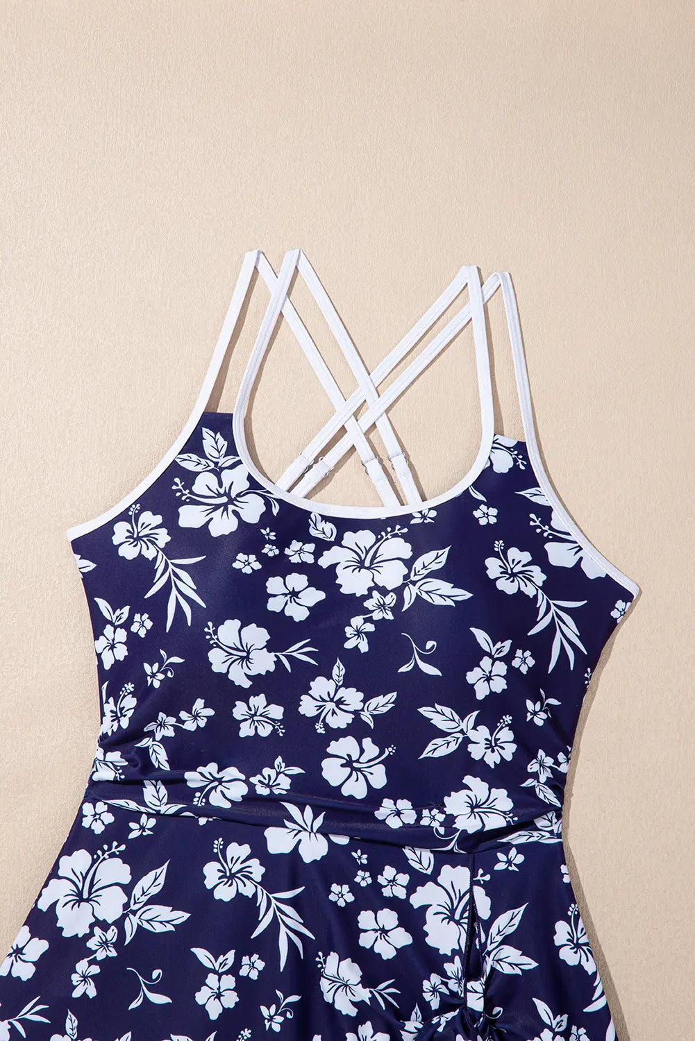 Navy blue dress with white floral pattern on a beige background