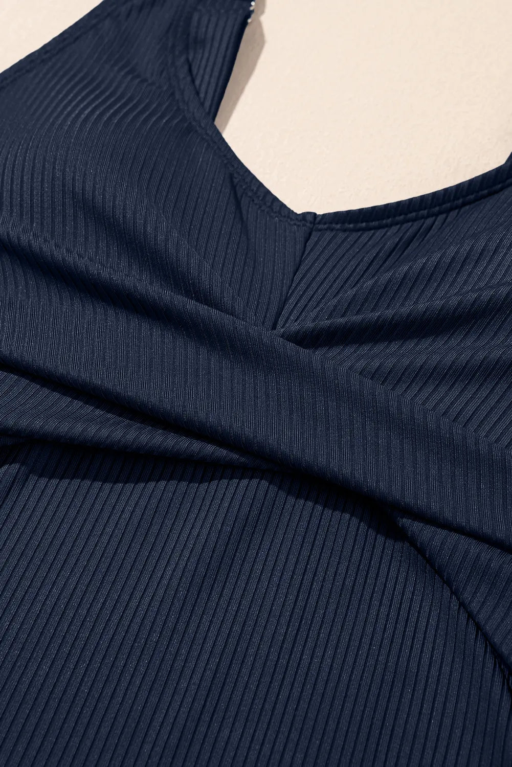 Navy ribbed sweater on a mannequin with a beige background