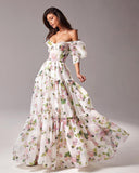 Woman wearing a floral off-shoulder gown against a gray background